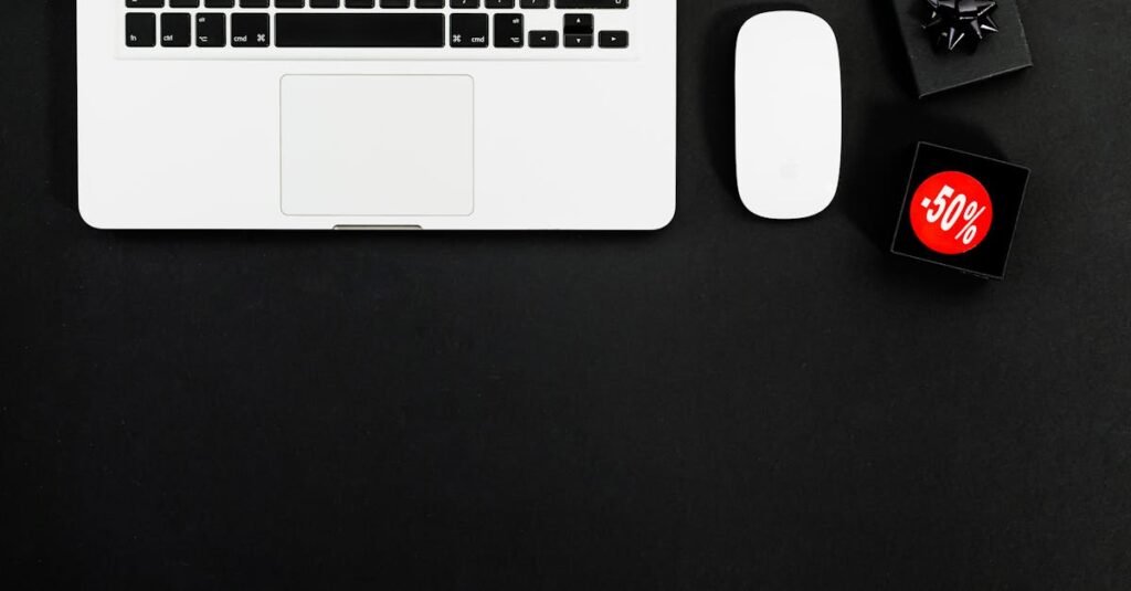 Minimalist flat lay featuring a laptop and shopping items with 50% sale tags.